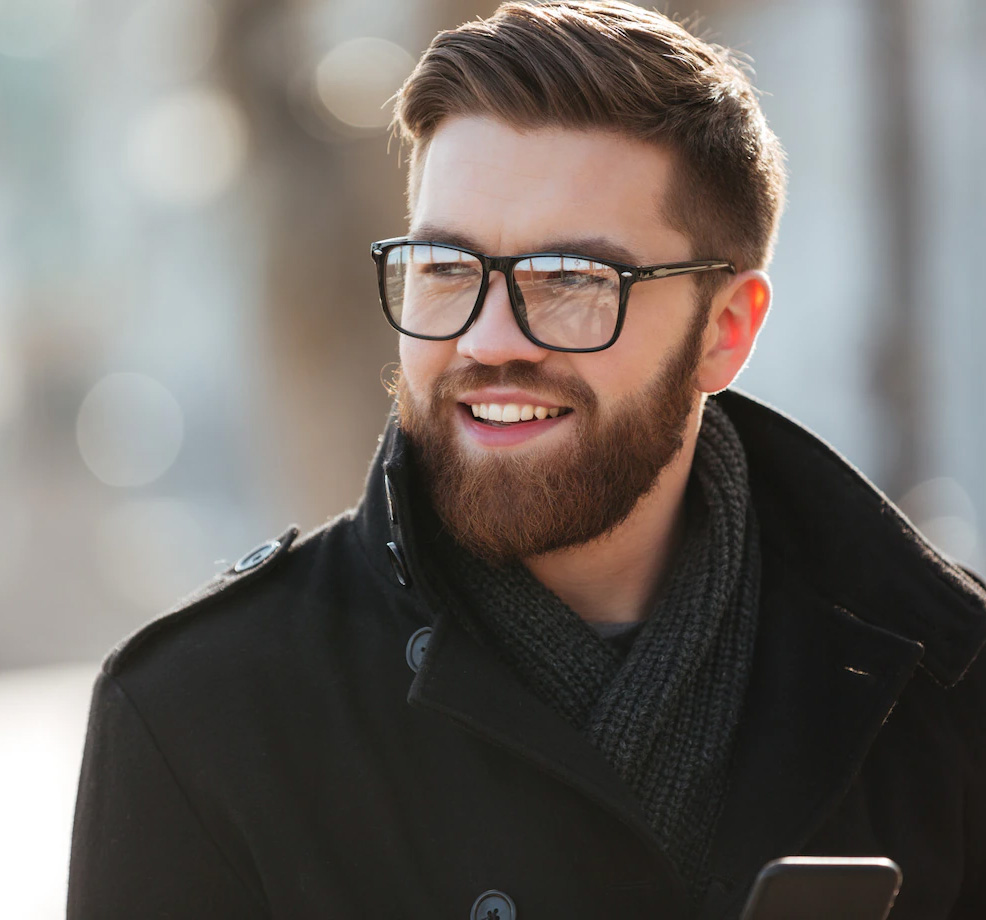 Homem branco, de óculos de grau e barba