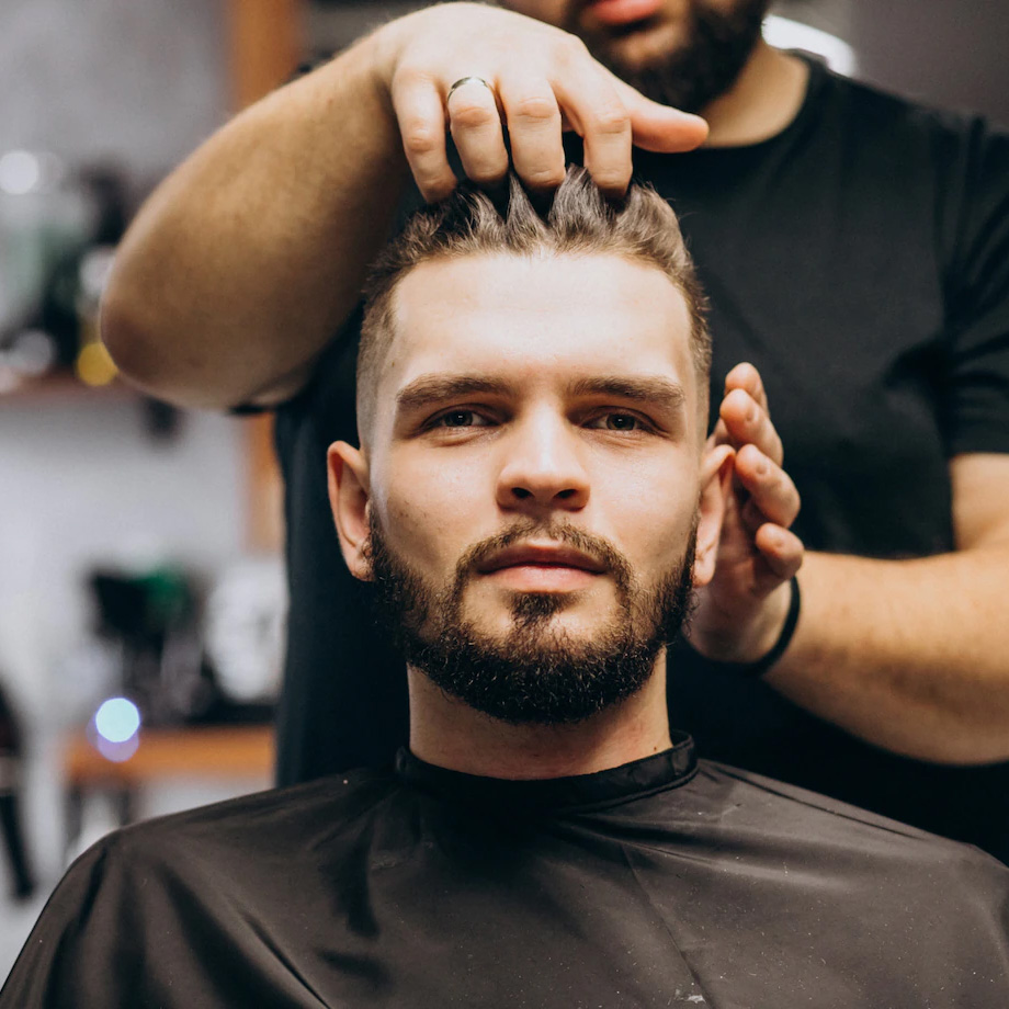 Barbeiro passando a mão no cabelo do cliente