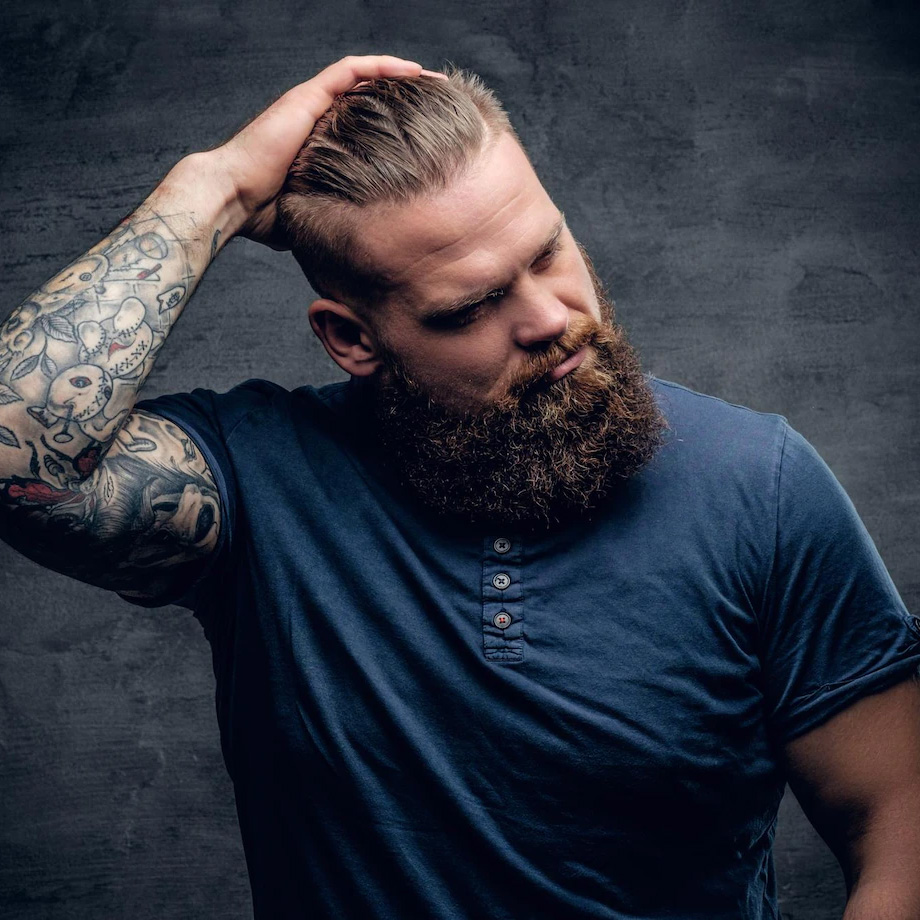 Homem barburdo passando a mão no cabelo